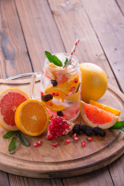 istock Refreshing sangria / punch with orange, pomegranate seeds, blackberry, and grapefruit on brown rustic wooden background 847622384