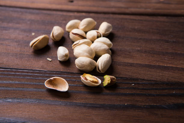 istock Salted pistachios on rustic brown wooden background 847629598