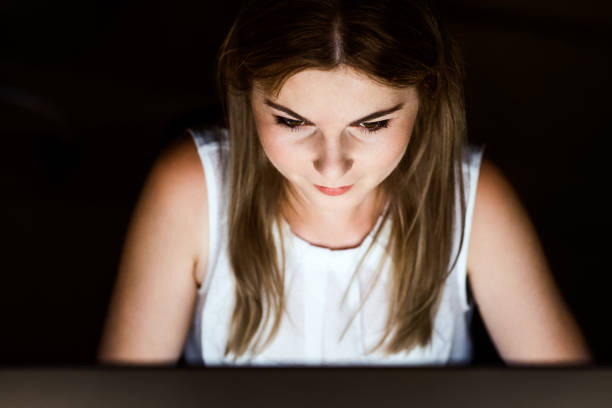 istock Businesswoman in front of computer screen in office at night. 847633080