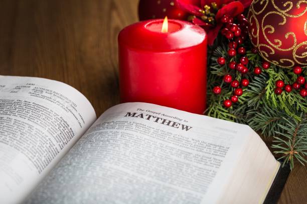 Christmas. Matthew bible with a big red candle and Christmas decorations bible gospel stock pictures, royalty-free photos & images