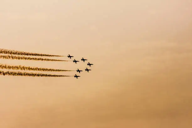 Seven airplanes of the turkish acrobatic squadron are flying in the sky during the sunset; in backlight - 9th september 2017 - Izmir (Turkey): anniversary of the liberation of the city from the greeks