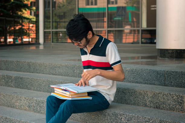 istock a young student in a t-shirt and glasses reading on face book 847657786