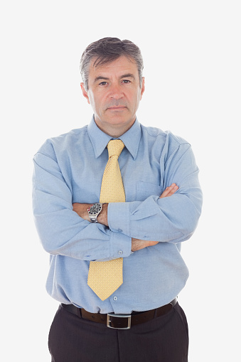 Portrait of confident mature businessman with arms crossed standing against white background