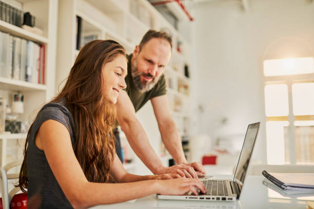 Single father helping teenager with her homework. Single father helping teenager with her homework. Barcelona. lens flare offspring daughter human age stock pictures, royalty-free photos & images