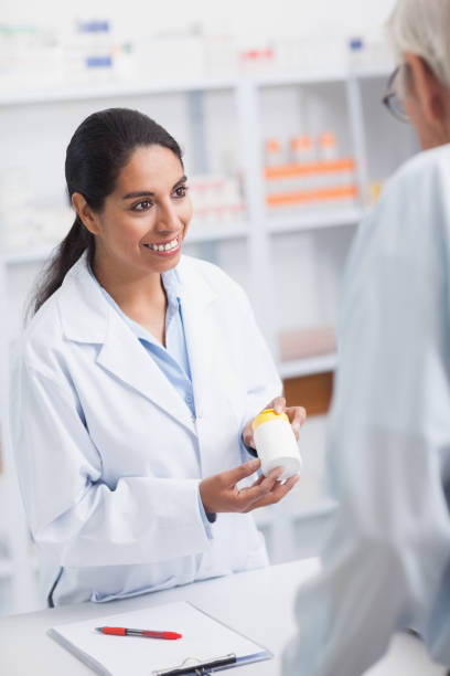 istock Pharmacist showing a drug box to a old man 847670866