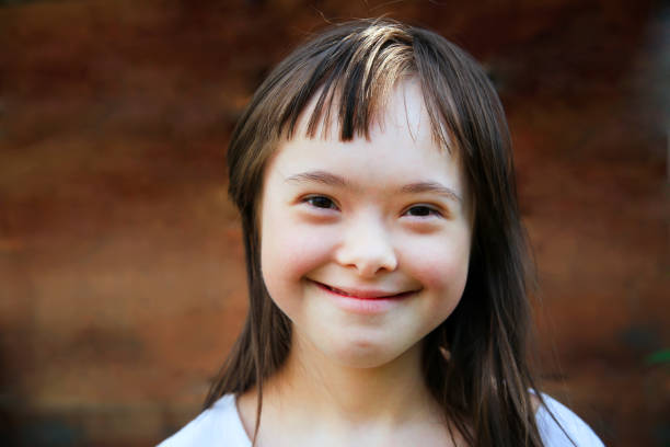 Cute smiling down syndrome girl Cute smiling down syndrome girl on the brown background down syndrome photos stock pictures, royalty-free photos & images