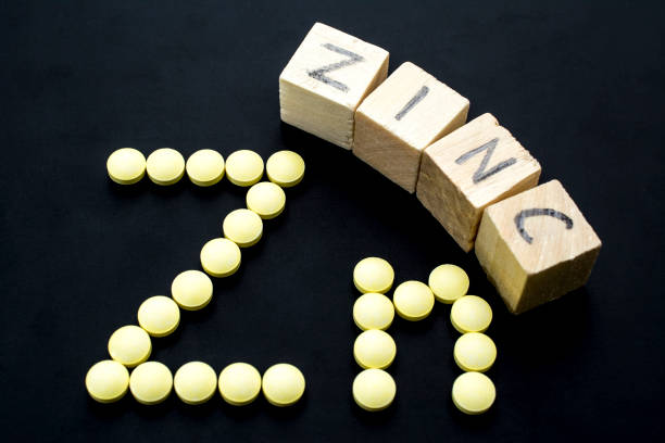 istock Yellow pills and wooden cubes forming Zn on a blackboard 847673910