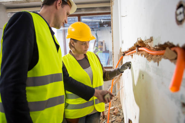 istock Male and female plumber measuring wall 847674056
