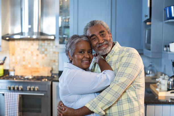 istock Portrait of couple embracing while standing in kitchen 847681696