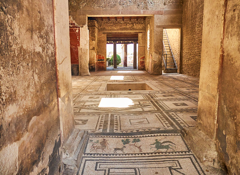 Pompei, Italy - August 9, 2017. Mosaics at entrance of archaeological remains of Domus di Paquio Proculo in Ruins of Pompeii. The city was an ancient Roman city destroyed by the volcano Vesuvius. Campania, Italy.