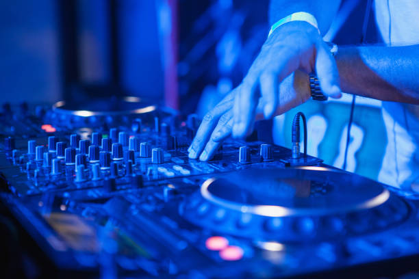 istock DJ playing music at mixer on colorful blurred background 847695520