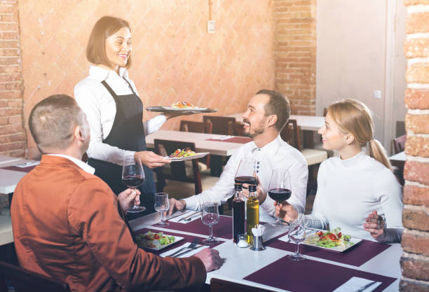 istock Female waiter bringing order to visitors 847699320
