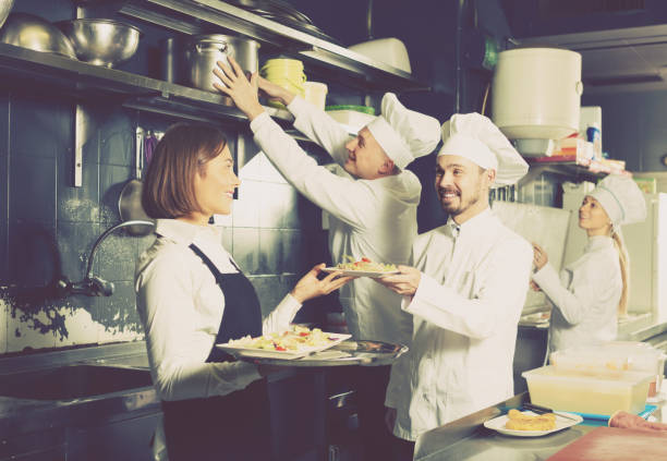 istock Cheerful female waiter taking ordered dishes 847701400