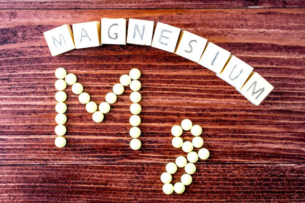 istock Magnesium labeled yellow pills on a wooden table - shaped in Mg 847702640