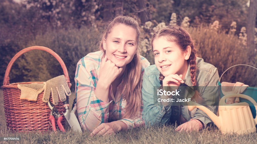 young mother and dauther with gardening tools in outdoors smiling  young english  mother and dauther with gardening tools in outdoors Admiration Stock Photo