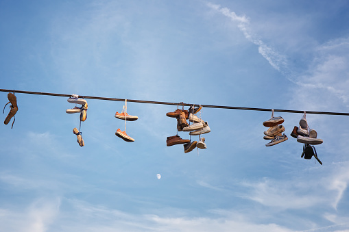 Shoes hanging on an electric cable