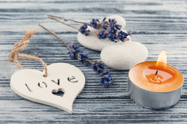istock Lavender flowers, orange lit candle and heart 847709656