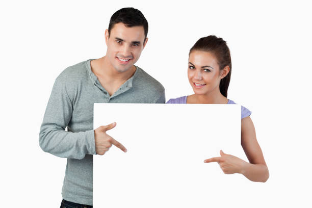 istock Young couple pointing at banner in front of them 847710050