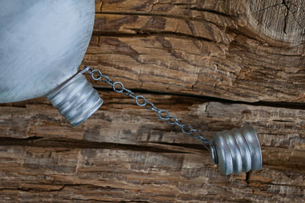 dehydration concept. empty vintage military aluminum canteen, water flask with cap unscrewed on coarse weathered wood background. - military canteen imagens e fotografias de stock