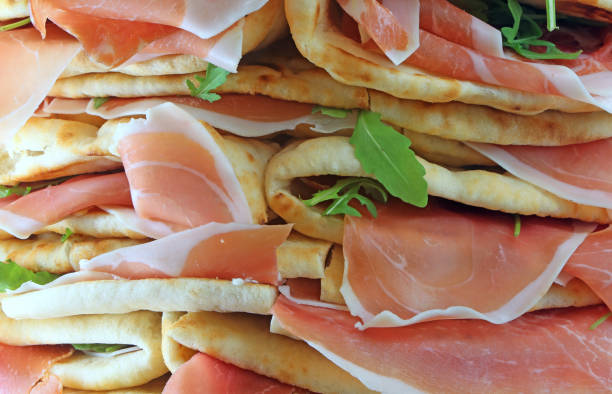 panini chiamati spianata o piadina in italiano con prosciutto crudo e - piadina foto e immagini stock