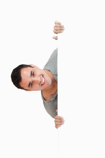 istock Smiling young male looking around the corner 847744842