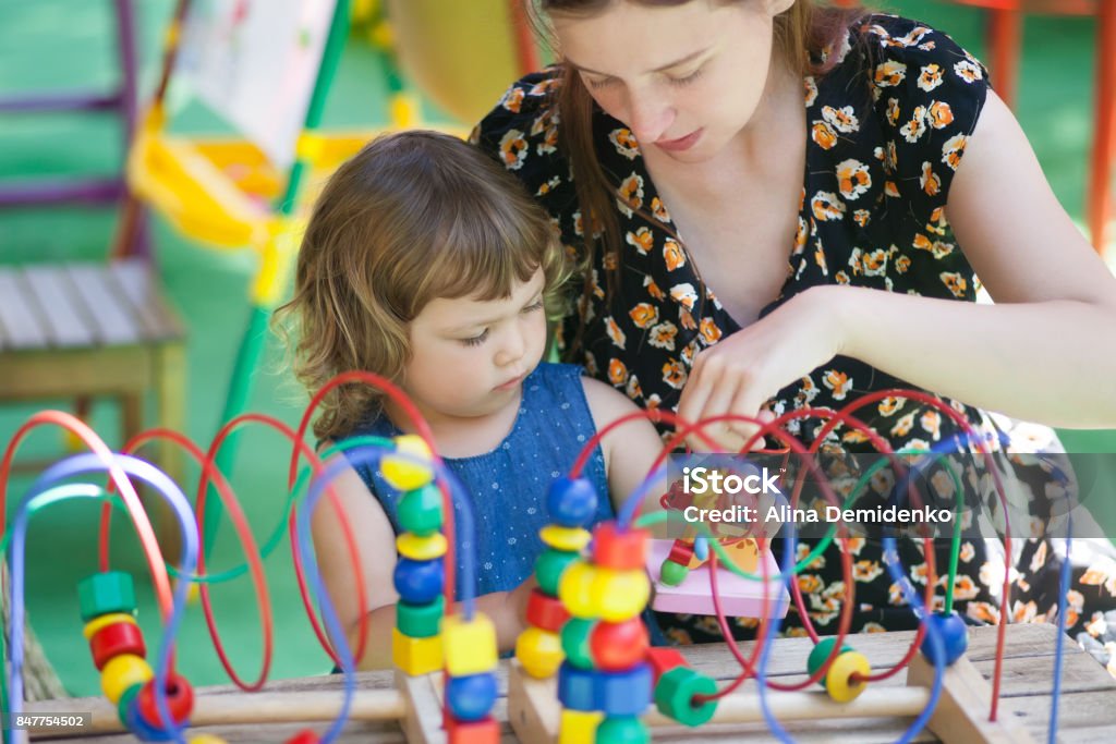 Niña y madre, jugando con el juguete educativo. - Foto de stock de La mañana libre de derechos