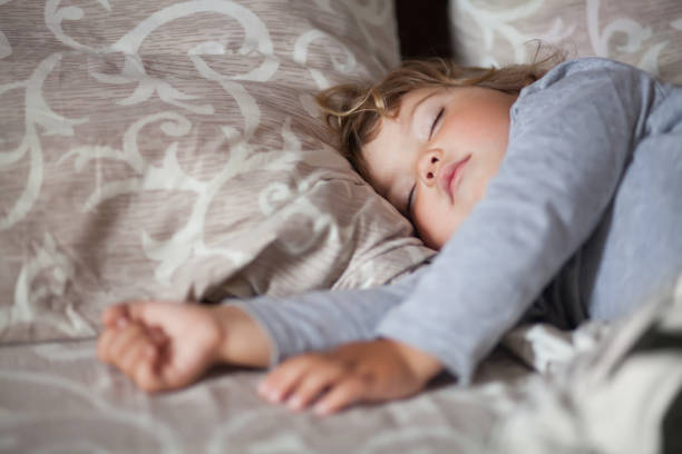 istock Adorable little girl sleeping in the bed. 847755156
