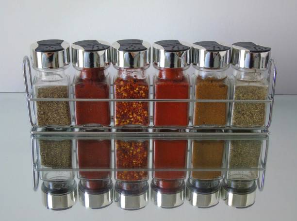 Spice Rack with Reflections Jars of herbs and spices in spice rack with reflection below spice rack stock pictures, royalty-free photos & images