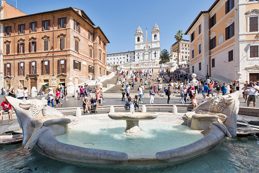 Italy, Rome - September 2017. Piazza di Spagna with Barcaccia fountain in foreground and Trinità dei Monti in background.
