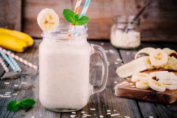 banana smoothie z płatkami owsianym w słoiku mason na drewnianym tle - yogurt jar cream milk zdjęcia i obrazy z banku zdjęć