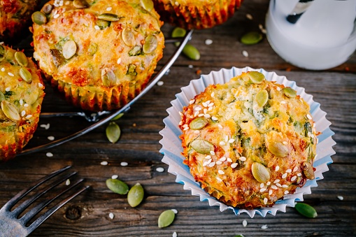 muffins with spinach,  feta cheese pumpkin seeds and sesame seeds on wooden background