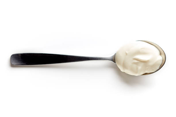 istock Sour cream in a spoon isolated on white, from above 847811132