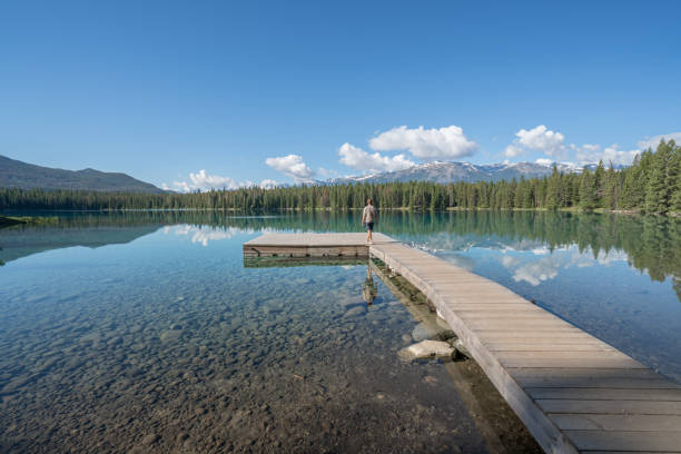 istock Young man relaxing on lake pier 847821730