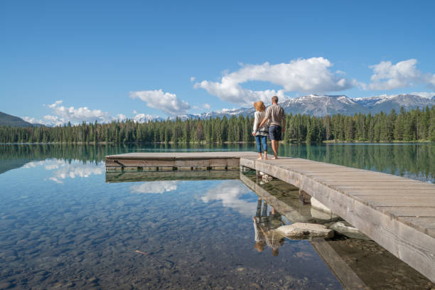 Cheerful young couple on lake pier sharing some relaxing moments.