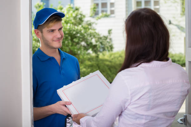 istock Man Delivering Pizza To Young Woman 847839686