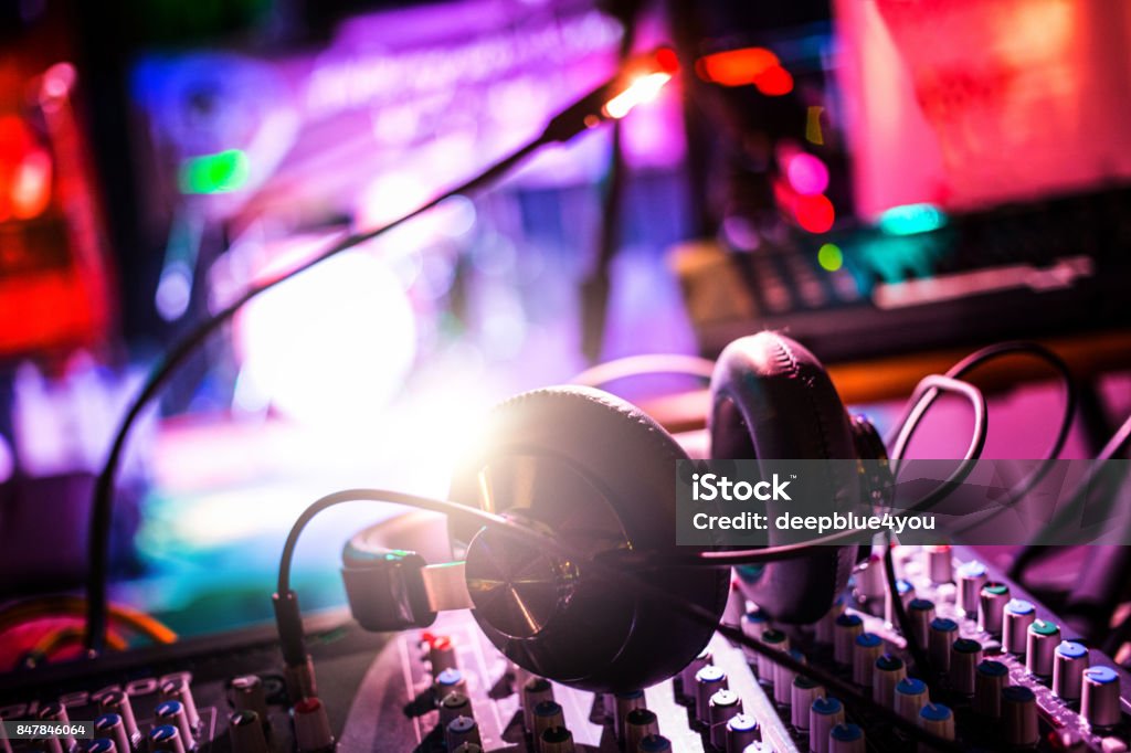 Headphones on the mixing console in nightclub Headphones On the mixing console Performance Group Stock Photo