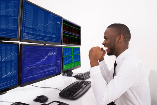 istock Happy Stock Market Broker Looking At Graphs On Multiple Computer 847846480