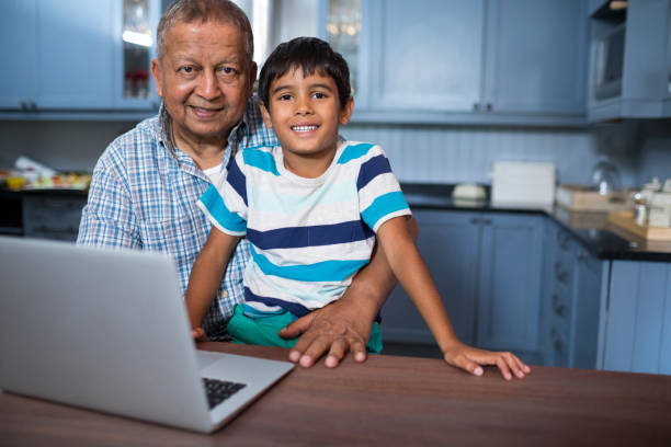 istock Portrait of grandfather with boy using laptop 847866850