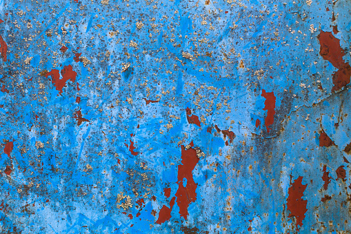 Texture rusty metal wall with peeling paint.