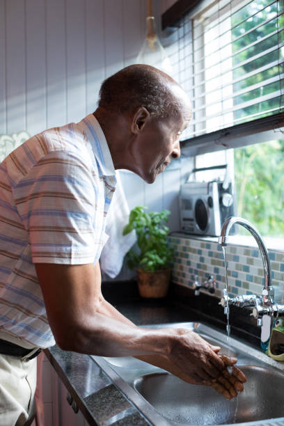 istock Side view of man looking away while washing hands 847868074