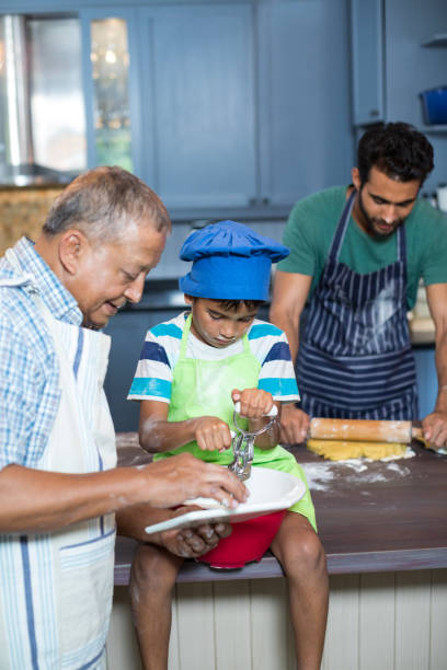 istock Grandfather showing tablet computer to boy while preparing food 847868080