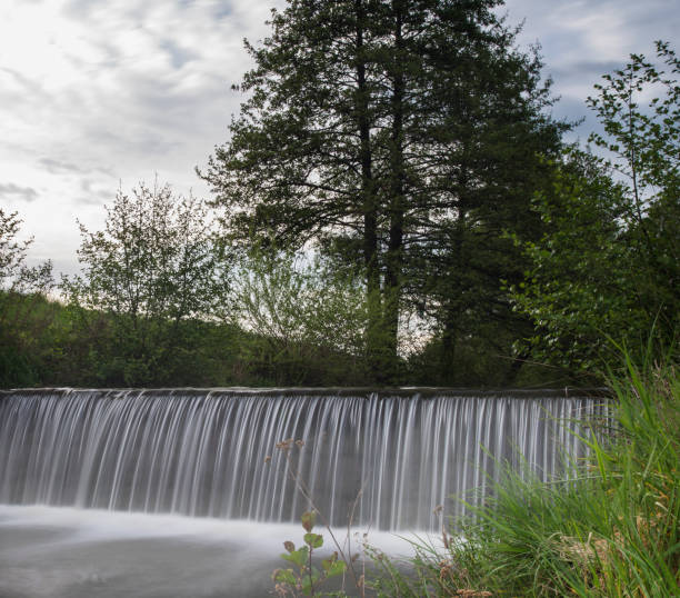 istock Milky waterfall admist summer green surrounding. 847877270