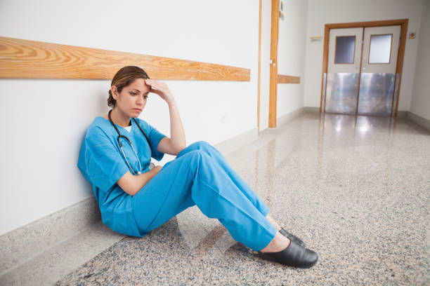 istock Nurse sitting on the floor hand on forehead 847879936