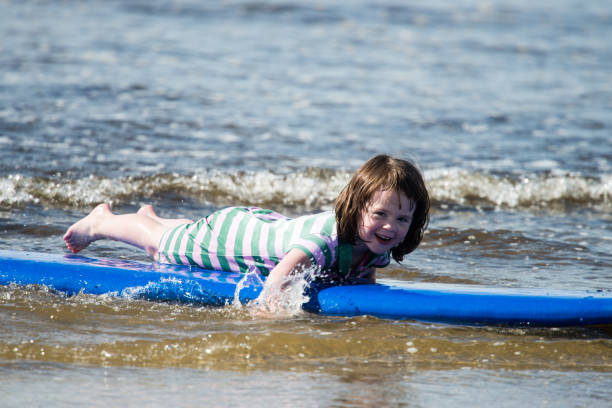 istock Young little girl on beach taking surfing lessons 847886166
