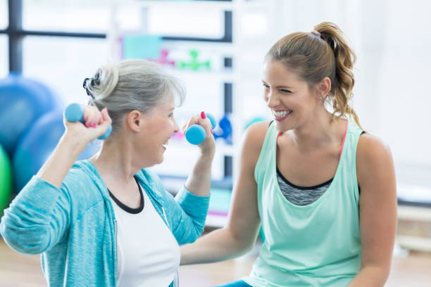 istock Fitness coach laughs with senior client during weight training 847889726