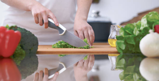 istock Close-up of four human hands are cooking in a kitchen. Friends having fun while preparing fresh salad. Vegetarian, healthy meal and friendship concept 847896422