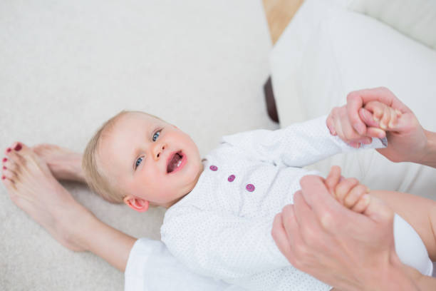 istock Mother sitting on a sofa while playing with a baby 847902318