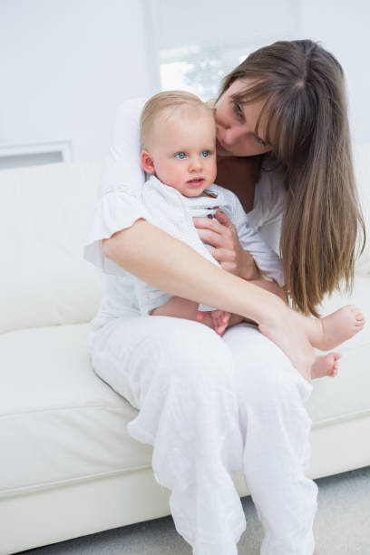 istock Baby sitting on his mother knees 847902334