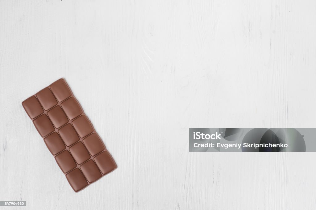 Tile milk dark chocolate Tile milk dark chocolate on a white wooden background isolation Back Stock Photo