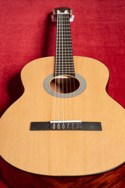 istock acoustic guitar on red velvet fabric, closeup object 847905474